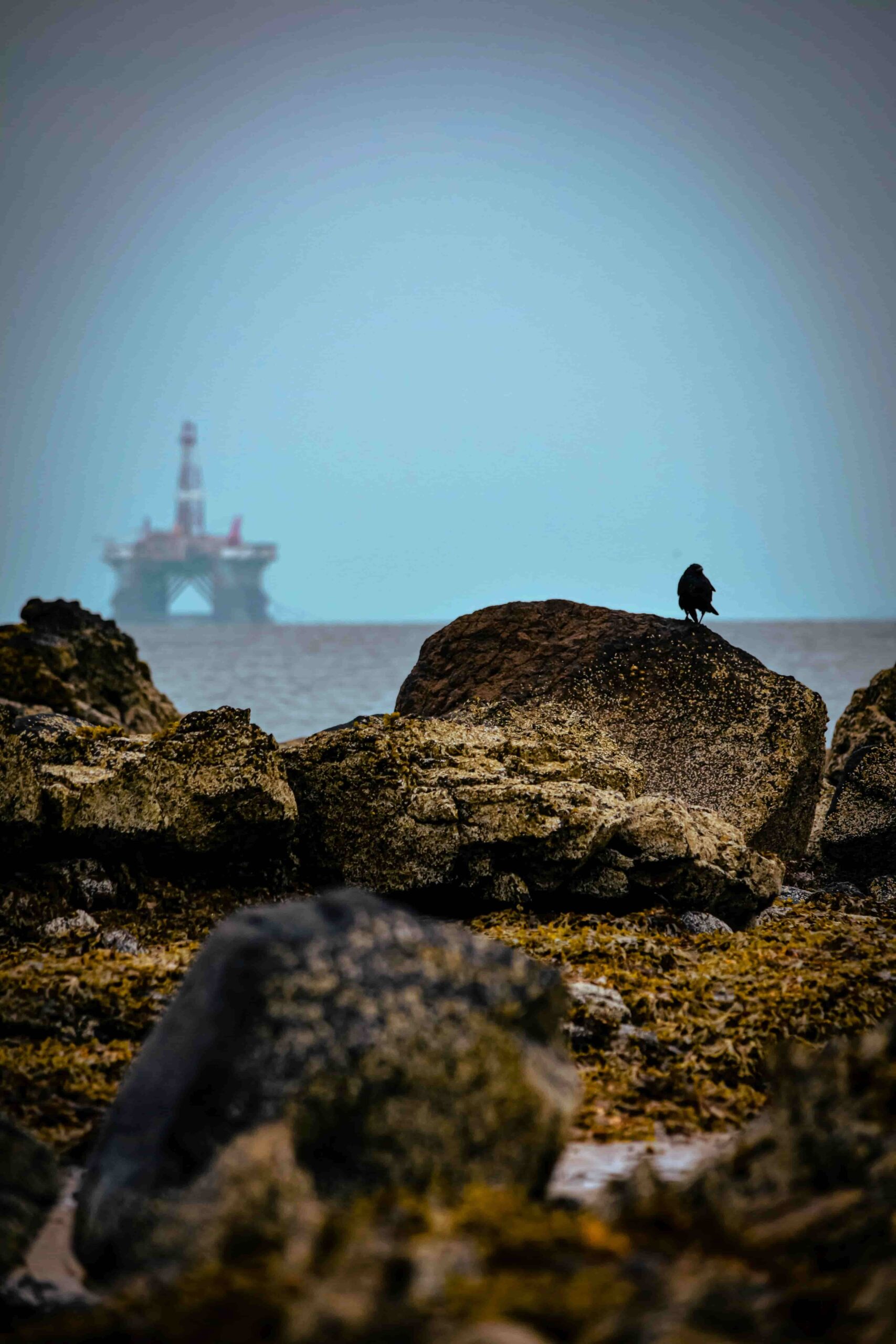 Ein Felsenmeer in Norwegen mit einer Offshore Plattform am Horizont